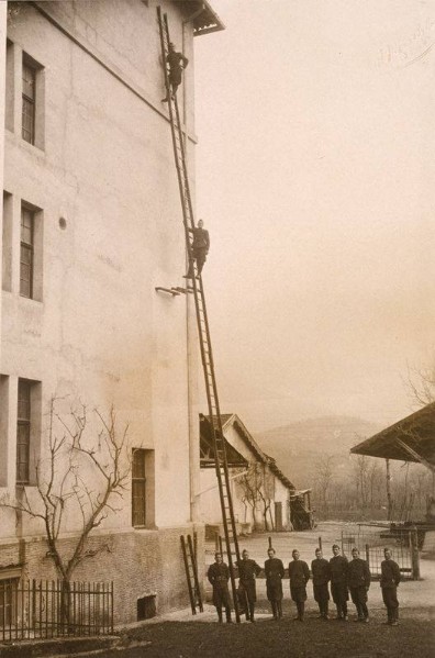 82) Il Corpo Pompieri Birra Pedavena durante una esercitazione con le scale sul muro esterno della malteria..jpg