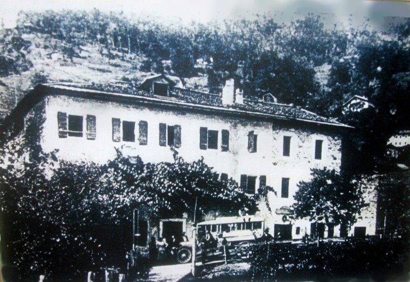 04-L'osteria -Alla California- L'osteria pian piano si ingrandische, attorno a questo edificio ruota tutta la vita di California, davanti la corriera  S.Giustina-Sospirolo-Gosaldo.(Anni '20).jpg