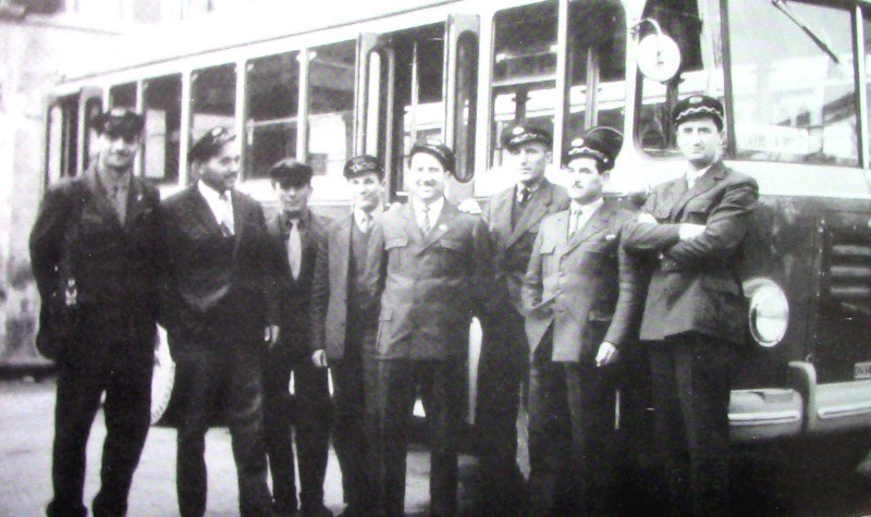 39) Anno 1956. Autobus Fiat 642 della ditta Buzzatti, addetto al servizio urbano, sosta in piazza Castello a Belluno. In primo piano gli autisti e i bigliettai.jpg