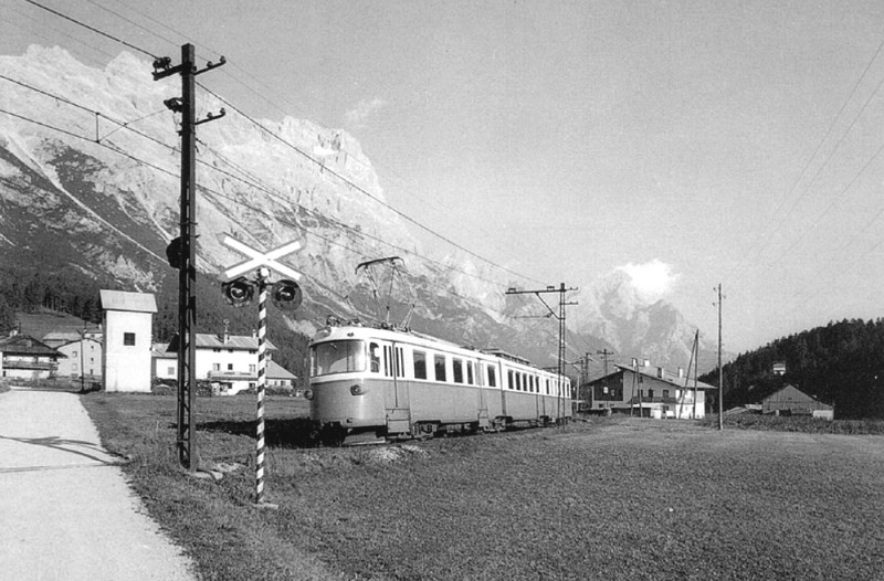 19a) Elettrotreno nelle vicinanze di Zuel. Vicino al traliccio con funzione di tirante, uno dei semafori a segnalazione automatica per passaggi a livello.jpg