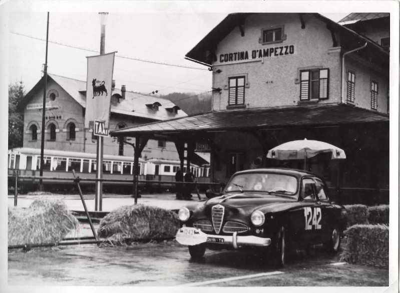 78d) Cortina-17 Settembre 1960,una Alfa 1900 fotografata alla stazione all'arrivo del 9° Trofeo Supercortemaggiore-Cortina).Sullo sfondo il nostro trenino..jpg