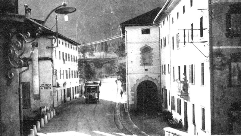 11) Agordo. Di fronte all'Albergo alla Posta, una corriera e il binario della ferrovia militare che collegava Agordo a Bribano..jpg