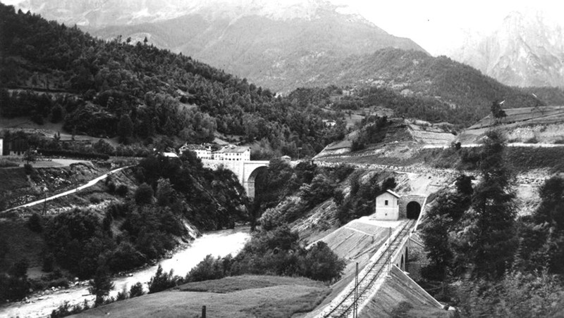 26) - Linea ferroviaria ed imbocco della galleria di PONTE ALTO (180 metri), sullo sfondo le montagne della conca agordina. In passato volevano costruire una diga in questo posto..jpg