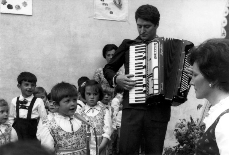 49-Franco barbier alla fisarmonica, la maestra dell'asilo e i bambini che cantano. San Gregorio nelle Alpi, pimi anni sessanta..jpg