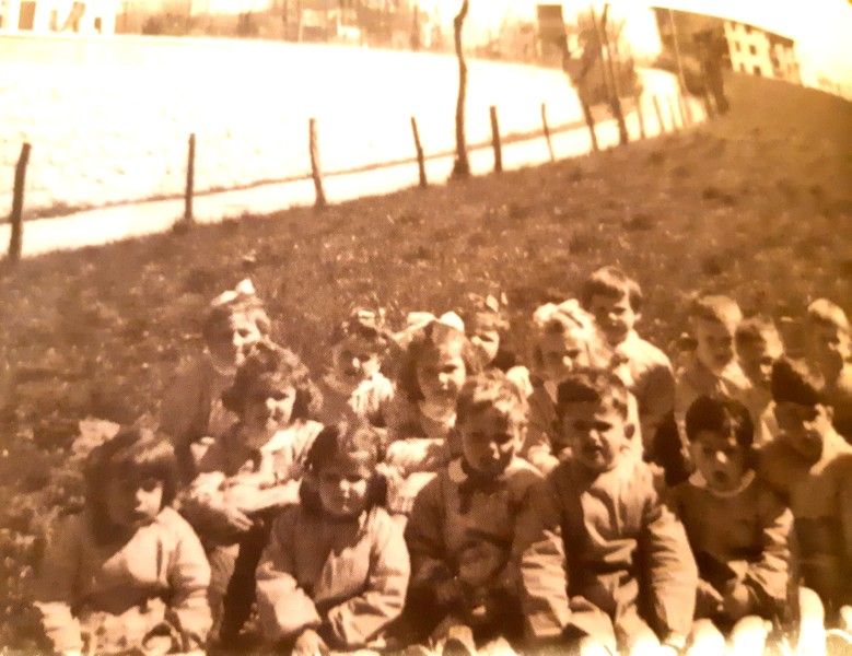 11-I bambini seduti sul prato delle -Candolere- un'area protetta da recinzione di paletti con filo spinato che vanno fino alla Donada..jpg