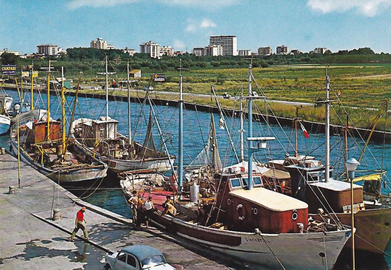 500-Porto Garibaldi  fine anni '60,  il portocanale con le barche. Sullo sfondo il panorama di Lido degli Estensi, con il condominio California che si staglia più in alto di tutti..jpg