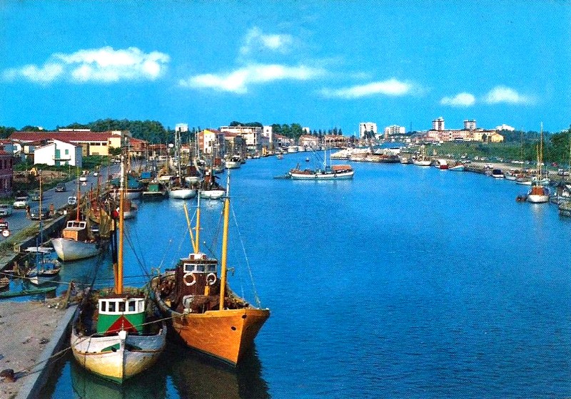 504-Il porto dal cavalcavia della Romea anni '60. Sulla sinistra  si possono notare ancora i resti dei bombardamenti che subì il portocanale durante la guerra,  Anno 1971..jpg